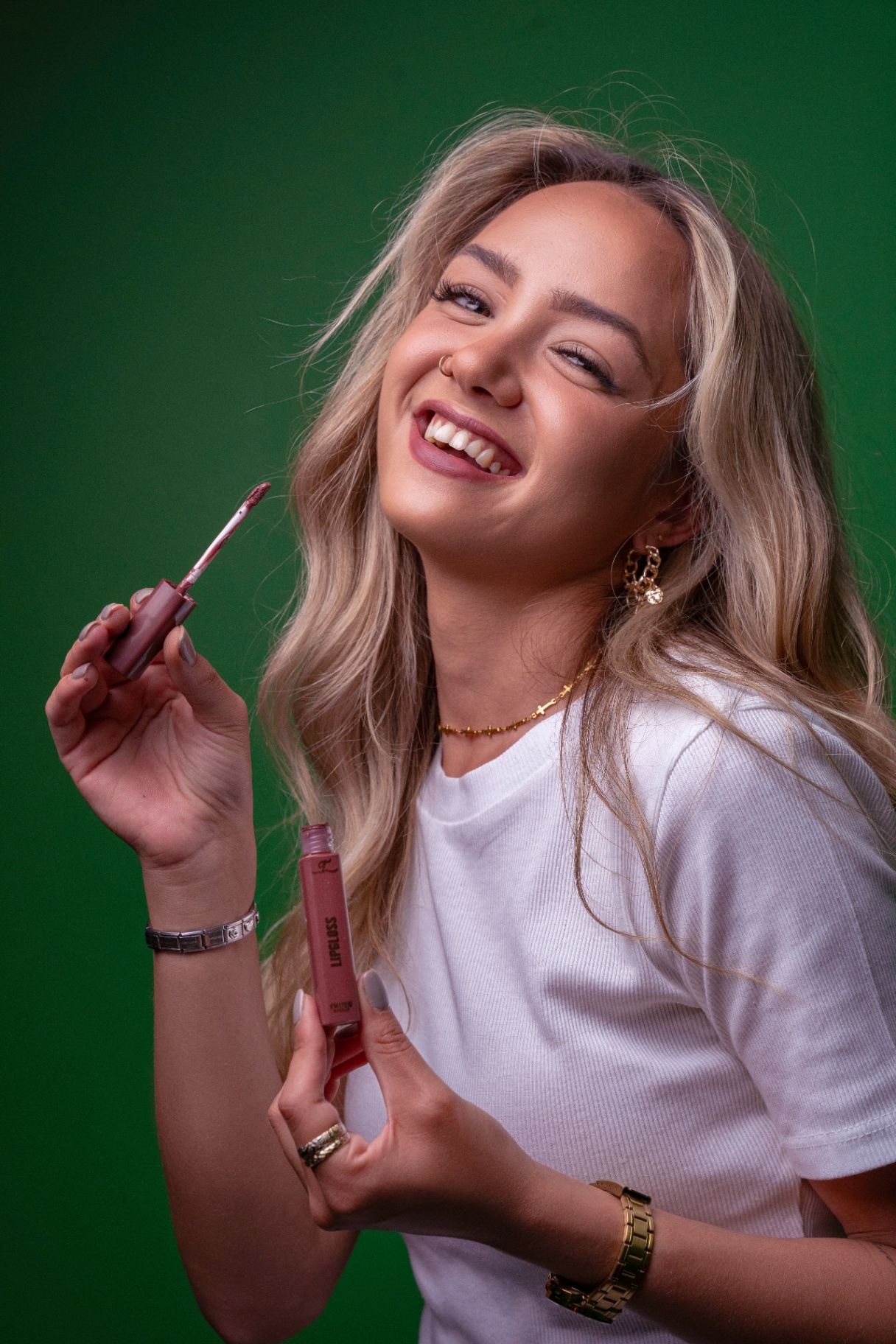 Model laughing with Truth lip gloss on green